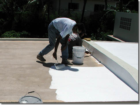 Roofer applying roof coating in Versailles, KY